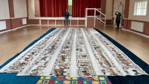 Julie Cave Replica of the Bayeux Tapestry is laid out in 6m lengths on the floor of a hall.