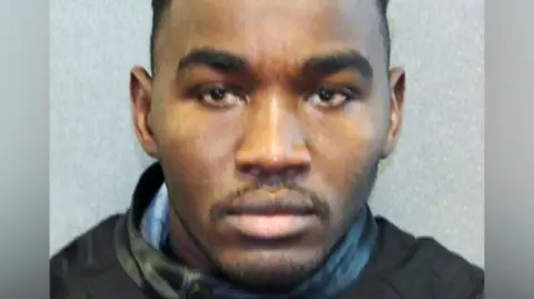 Headshot of Badreddin Abdalla Adam Bosh - a man with short, dark, hair and a short beard, looking straight into the camera.