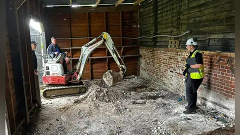 Met Police/PA Digger excavates barn at Stocking Pelham