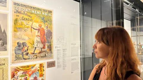 Imogen Foulkes Letizia Pinoja kijkt naar een vintage poster op een tentoonstelling over het koloniale verleden van Zwitserland