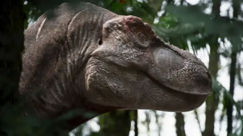A T. rex's head looks to the right, standing amongst trees 