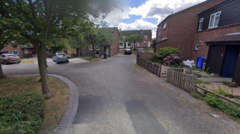  Streetview picture of Hallam Court in Ilkeston, a cul-de-sac with semi-detached homes and cars parked outside