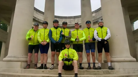 Team of cyclists at war memorial