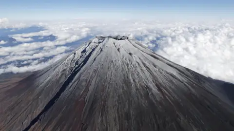 Reuters Top of Mt.Fuji is covered by snow in this photo