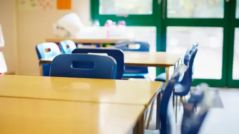 Getty Images A general view of a classroom with wooden desks and blue chairs