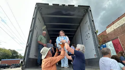 Volunteers load supplies into a truck for those affected by Hurricane Helene