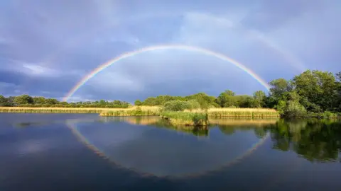 Beely from Barton A double rainbow spans the sky above Barton-upon-Humber, the rainbows are reflected in the still dark blue waters on 