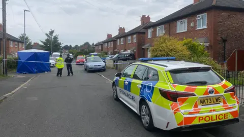 A police vehicle in front of the cordon on Barnard Road. 