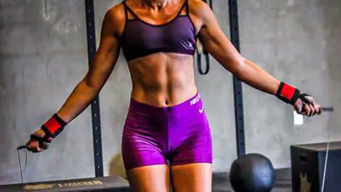 Gabriona's will image of a muscular woman wearing purple gym clothes, skipping rope in the gym