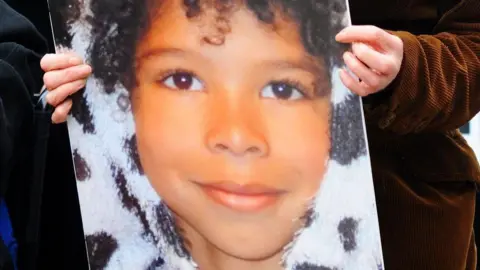 A photo of a child being held by two hands. 