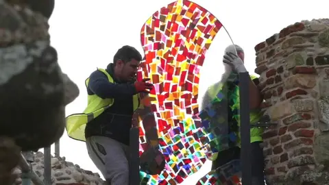 Stained-glass window being installed