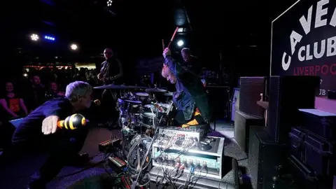 PA Media Zak Starkey, son of Sir Ringo Star, on drums performing with fellow band members (left to right) Bez, Shaun Ryder and Andy Bell of the Mantra of the Cosmos at The Cavern Club, Liverpool.