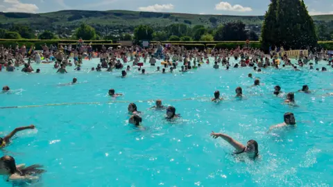 PA Media People swimming in the lido