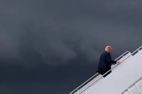 Leah Millis / Reuters President Donald Trump climbs the stairs to board Air Force One