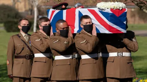 PA Media The coffin of Captain Sir Tom Moore is carried by members of the armed forces during his funeral at Bedford Crematorium