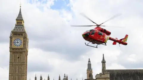 Getty Images Red air ambulance helicopter flies past Big Ben 