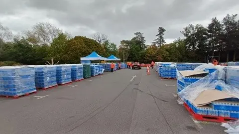 Thames Water Pallets of water at a bottled water station at Forty Hall Estate.