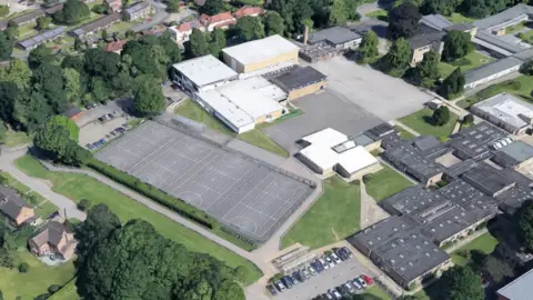 Google An aerial view of ELA Active Impington, showing the whole sports centre site, including netball courts at the centre of the plans, along with other buildings on the site, surrounded by trees and residential properties