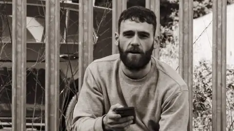 Francis Reilly Black and white photo of Francis Reilly holding a phone