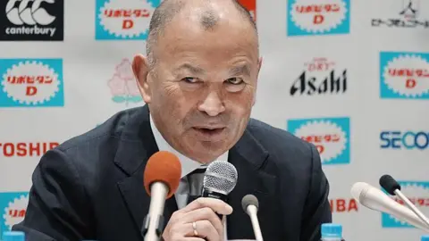 Eddie Jones speaks into a microphone