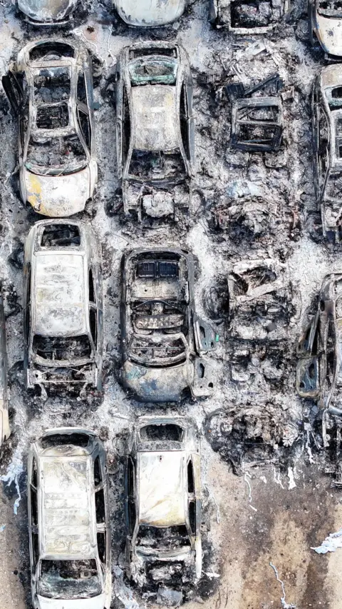 Aerial shot of lots of burnt out cars 