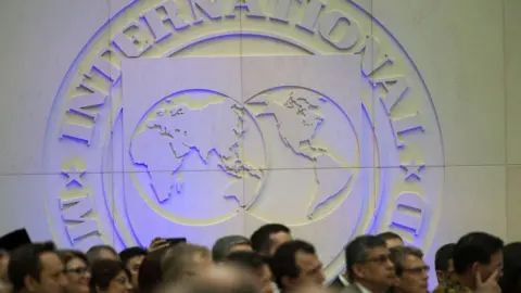 Getty Images People watch as International Monetary Fund (IMF) managing director, Christine Lagarde speaks during opening remarks for the upcoming 2018 General IMF Meetings in Washington DC on October 1, 2018.