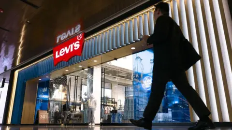 Getty image silhouette of a man walking through a store selling Levi jeans