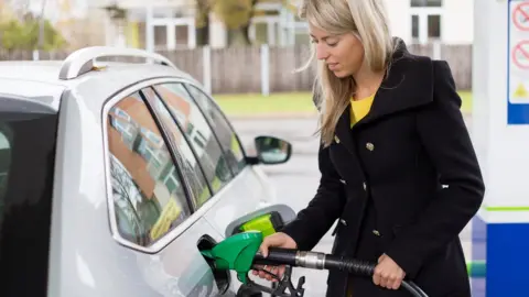 Getty Images woman filling car with fuel