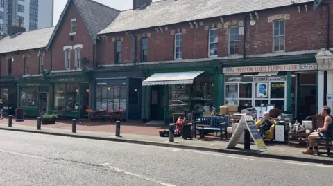 BBC Row of shops including Heaton Perk Cafe and 109 General Store on Heaton Park road in Newcastle.