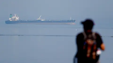 A silhouette watching the MT Desert Kite oil tanker carrying Russian oil at Narara Marine National Park in the Arabian Sea, Gujarat.

