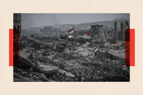 Anadolu via Getty Images Palestinian flags are seen among the rubble of destroyed buildings