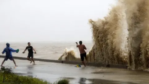 EPA residents play in waves in Aparri, Cagayan province