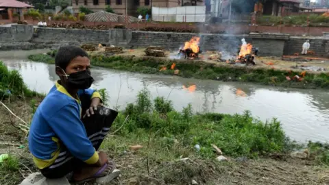 AFP A boy watches funeral pyres of people who died due to Covid