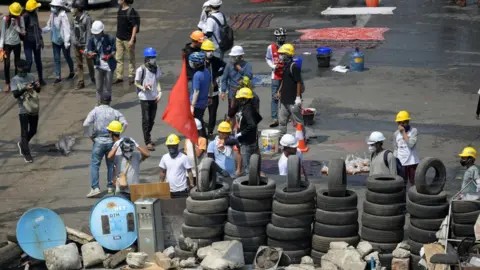 Reuters Protesters are seen in a barricade during an anti-coup protest in Yangon, Myanmar