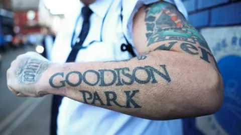 EPA An Everton fan displays his tattooed arm reading Goodison Park