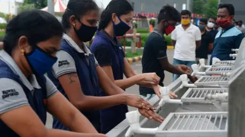 Getty Images Workers washing their hands upon their arrival at the Royal Enfield motorcycle factory after the government eased a nationwide lockdown imposed as a preventive measure against the COVID-19 coronavirus, in Oragadam, Tami Nadu.