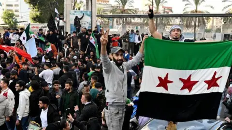 EPA Crowds of people waving flags in Damascus after the fall of the Assad regime in Syria.