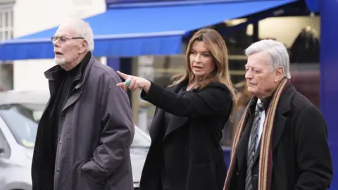 PA Media Bob Harris (left), Suzi Perry and Tony Blackburn arrive at the funeral of DJ Johnnie Walker at St Peter's Church in Shaftesbury, Dorset.