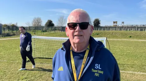 Steve Lancaster, founder of pan disability side Thanet Galaxy FC, stands on pitch at The Hive with goalkeeper David Benson in the background