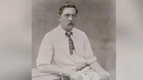 E.Hawkins & Co A black and white image of Ted Peate in his cricket whites.