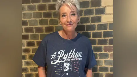 Actress Dame Emma Thompson in a dark grey T-shirt with a picture of Terry Jones and the slogan A Python on the prom
