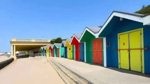 Nadezna / BBC Weather Watchers Colourful huts are seen lined up along a beach