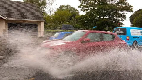 Simon Luckman Car driving through water causing large spray