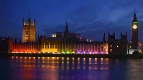 Houses of Parliament lit up with the rainbow flag