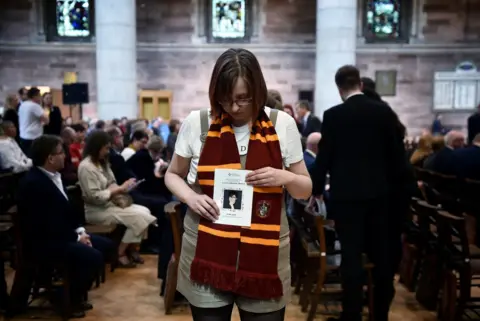 Charles McQuillan/REUTERS A friend of Lyra McKee holds an order of service as she attends the murdered journalist's funeral at St Anne's Cathedral in Belfast
