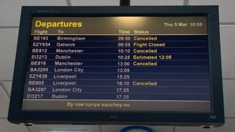 Airport sign listing flight departures/cancellations