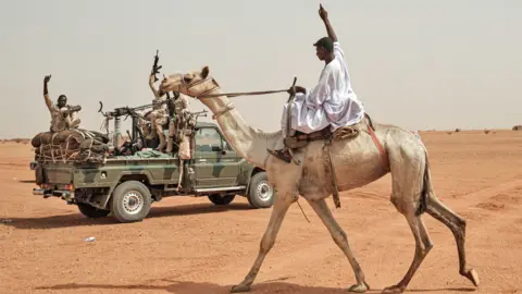 AFP A man riding on a camel greets members of the Rapid Support Forces (RSF) paramilitaries before a rally in Abraq, in 2, 2019. (P