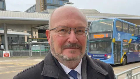 Shaun Whitmore Graham Plant in front of bus