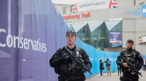 West Midlands Police Two armed policemen dressed in black holding a gun