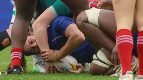Screengrab of a rugby match where a player in blue appears to bite the arm of another player